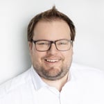 Portrait professionnel de Célestin Ferland, président de Neo TMS, sourire chaleureux en chemise blanche