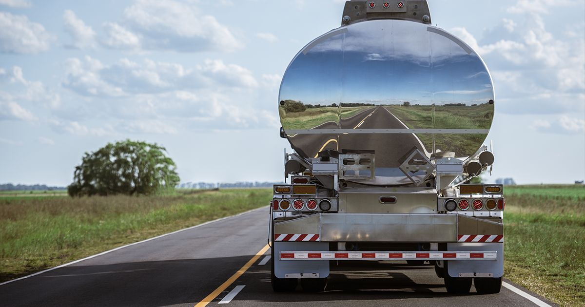Camion-citerne sur une route ensoleillée. Neo Répartition Pétrole anticipe les besoins des stations-service, planifie le réapprovisionnement et optimise vos voyages pour éviter toute rupture de carburant.