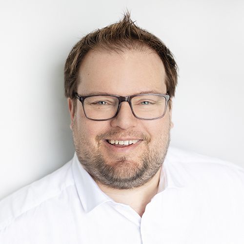 Portrait professionnel de Célestin Ferland, président de Neo TMS, sourire chaleureux en chemise blanche