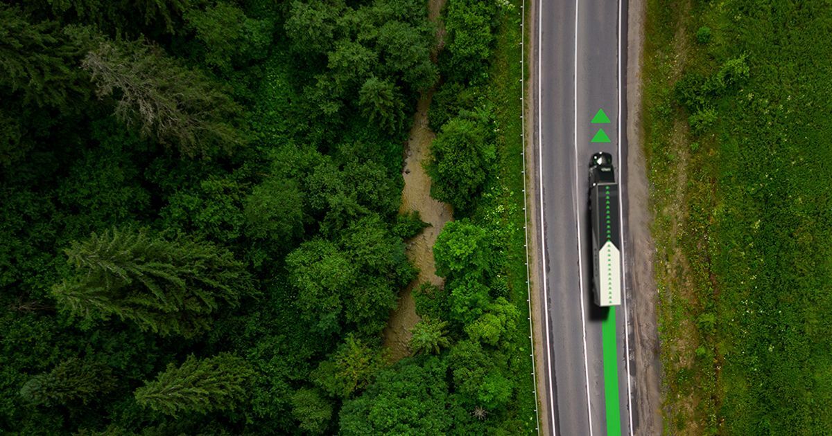 Camion sur une route entourée de forêt, vu du ciel. Neo TMS, solution complète de gestion du transport routier, optimise vos opérations de la commande à la facturation et maximise votre rentabilité.