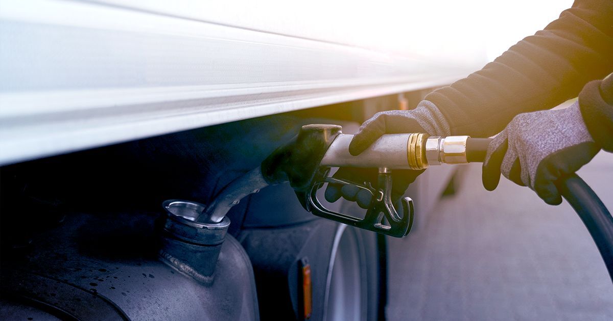 Conducteur de camion lourd faisant le plein de carburant, illustrant Neo Énergie, la solution de Neo TMS pour optimiser les coûts de diesel et réduire les dépenses en transport routier.